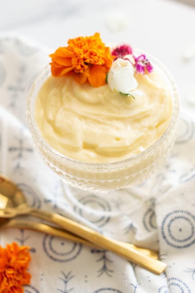 Gluten-free pudding in a glass dish with edible flowers