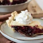 Razzlberry pie on a plate with whipped cream