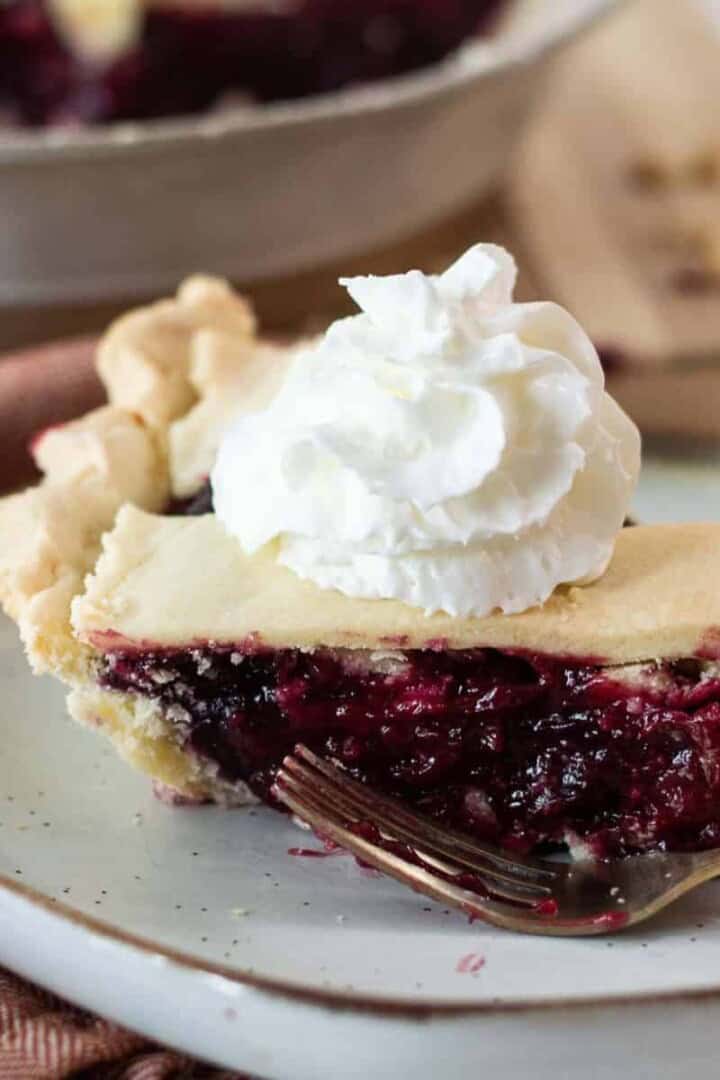Razzlberry pie on a plate with whipped cream