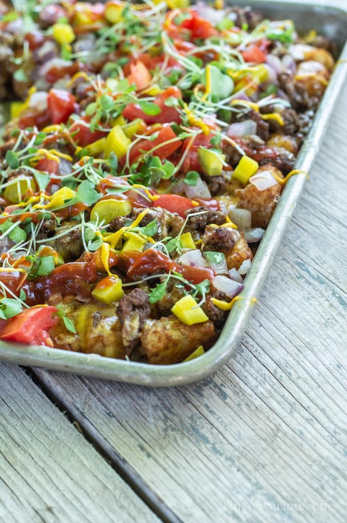 Cheeseburger loaded tots on a baking sheet