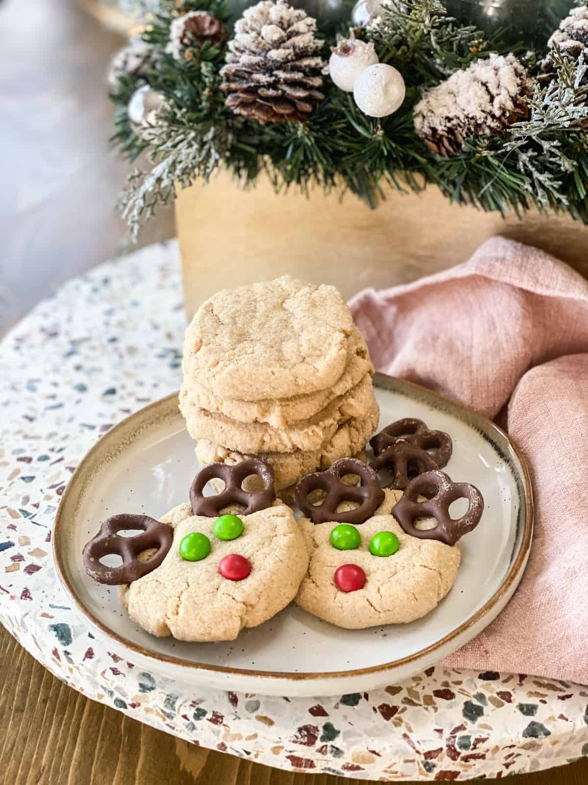 Reindeer cookies on a plate with a little towel next to it