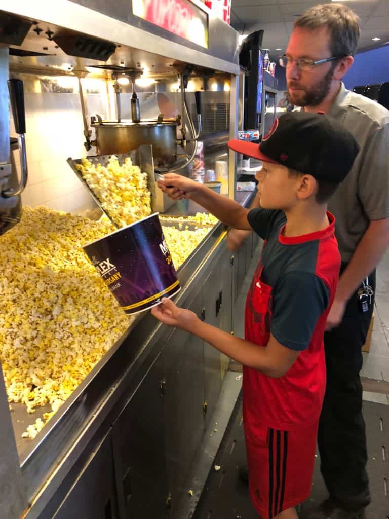 Kid putting popcorn in a bucket