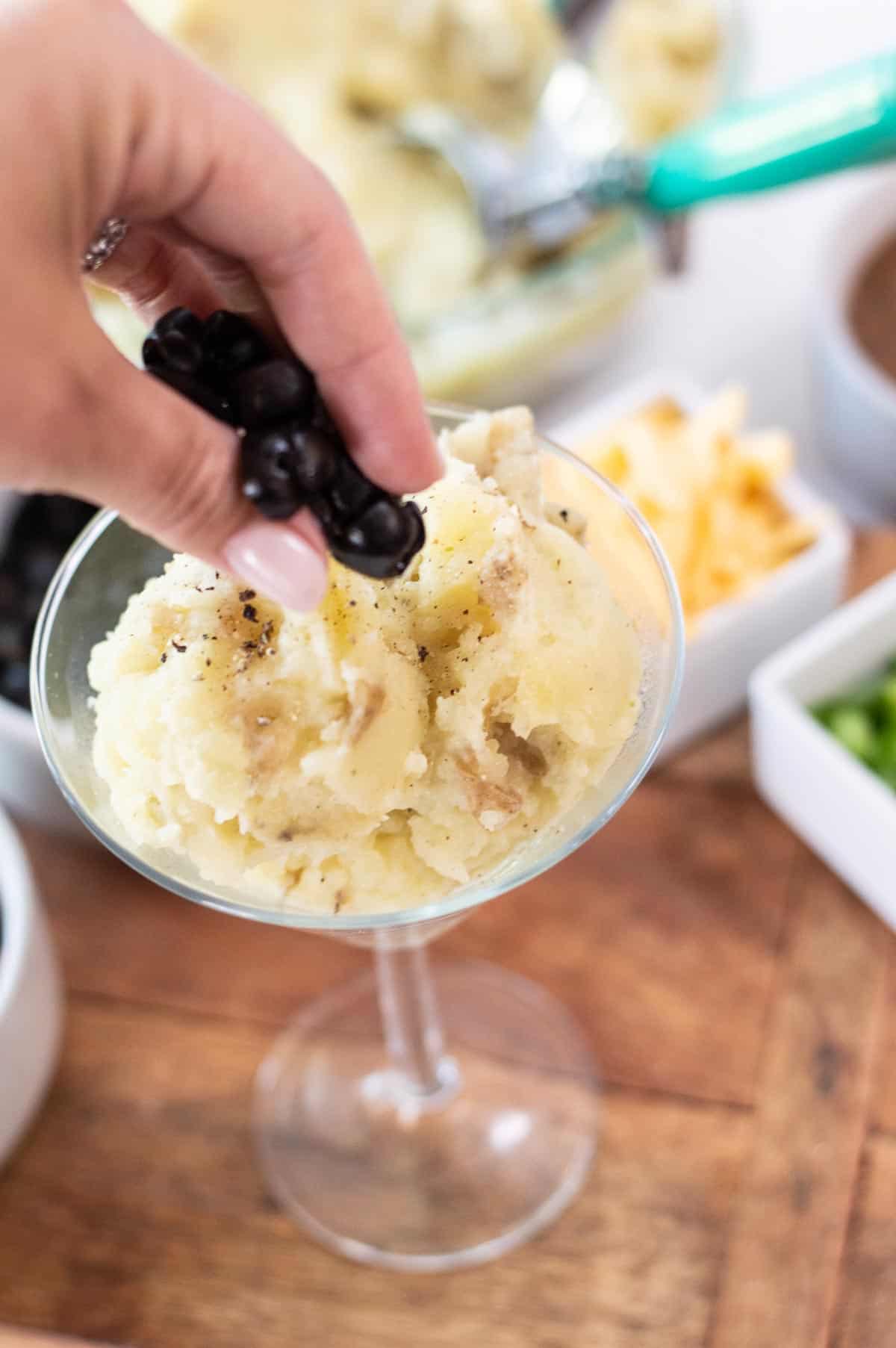mashed potatoes in a martini glass with olives