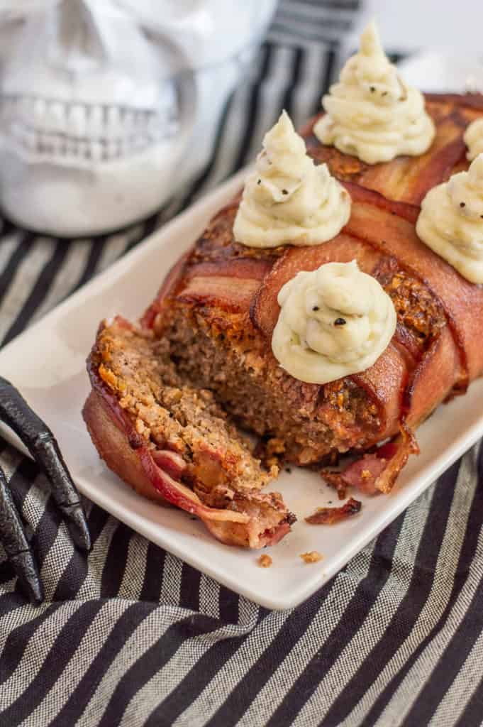 Bacon wrapped meatloaf on a white plate