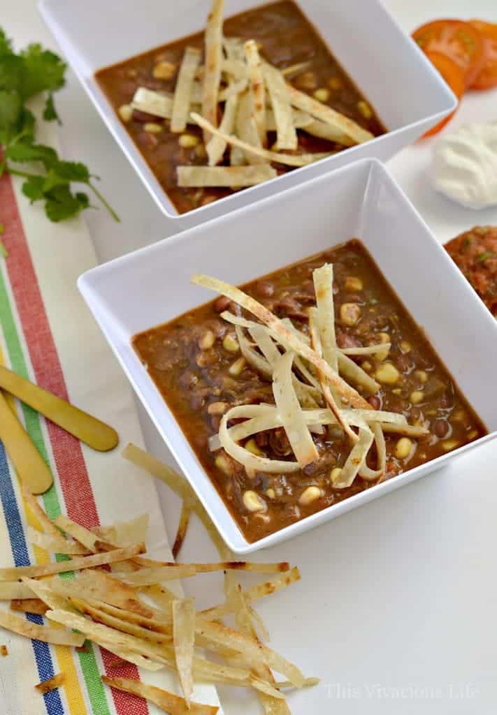 Shredded beef crockpot taco soup with tortilla strips in a bowl