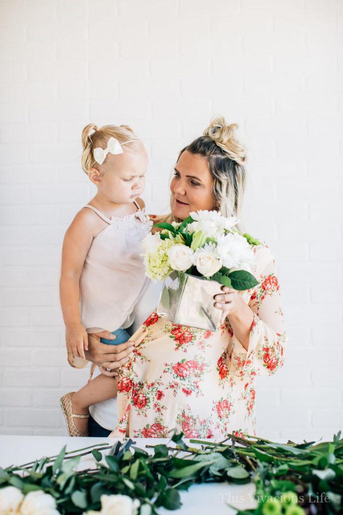 Mom and little girl with modern white flower arrangement