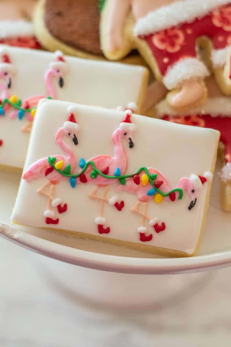 White frosted sugar cookie with Christmas flamingos