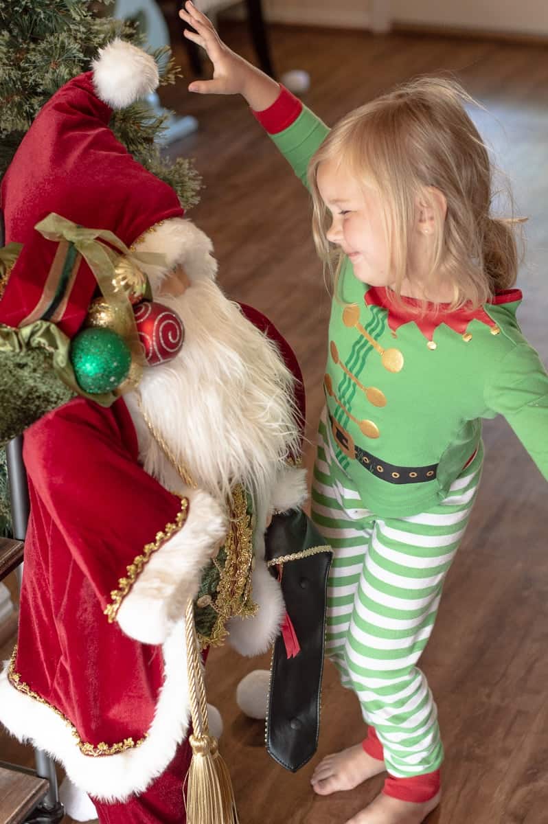 Santa decoration with little girl in Christmas pajamas