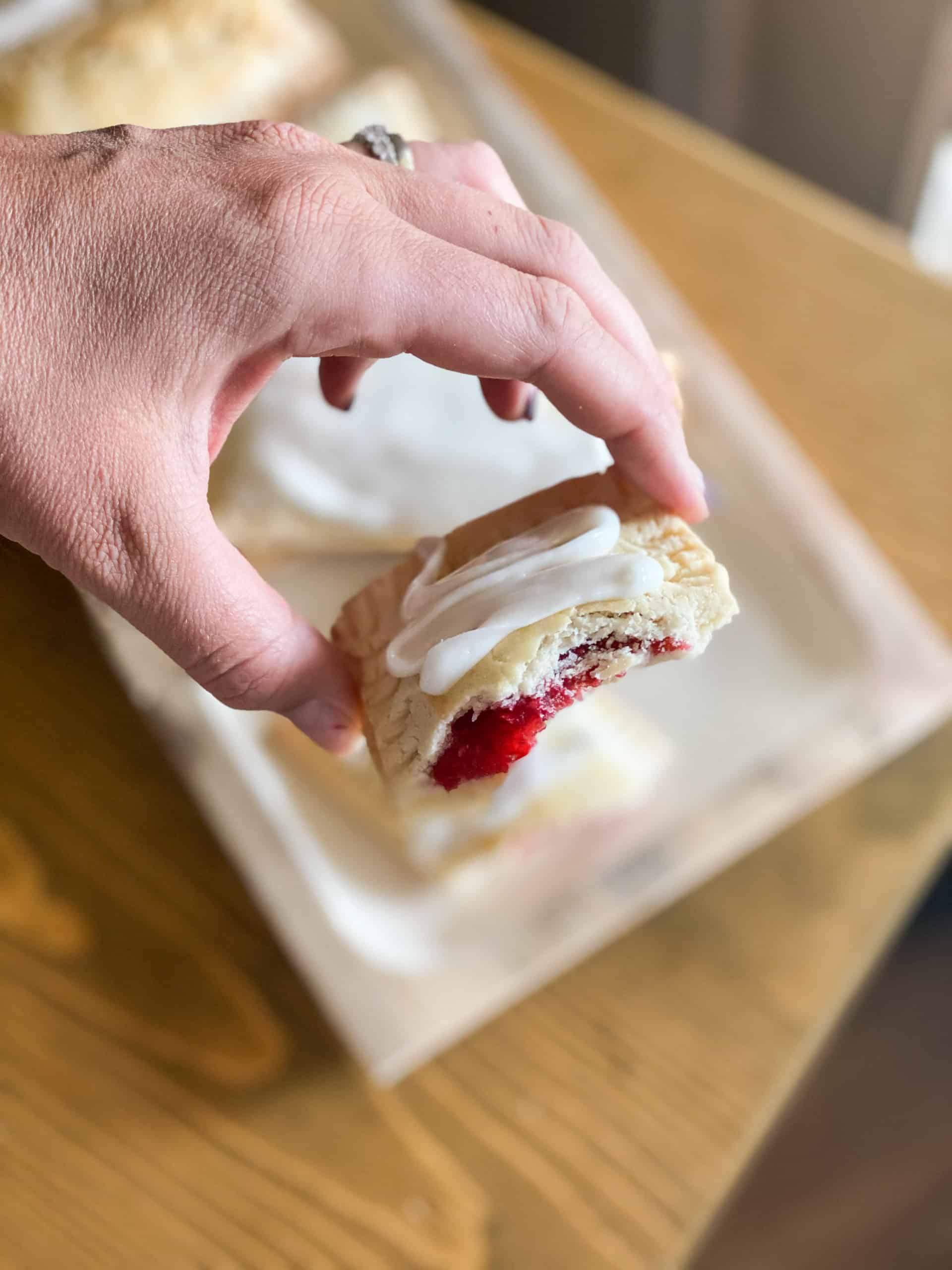 Gluten-Free Pop Tarts in a hand with raspberry filling