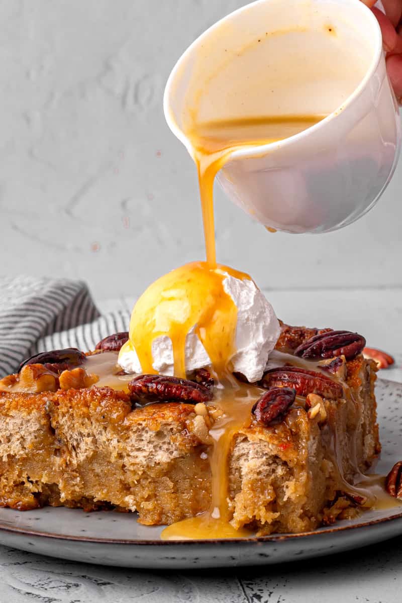 Pecan pie bread pudding with icecream on top and buttermilk syrup being poured on top