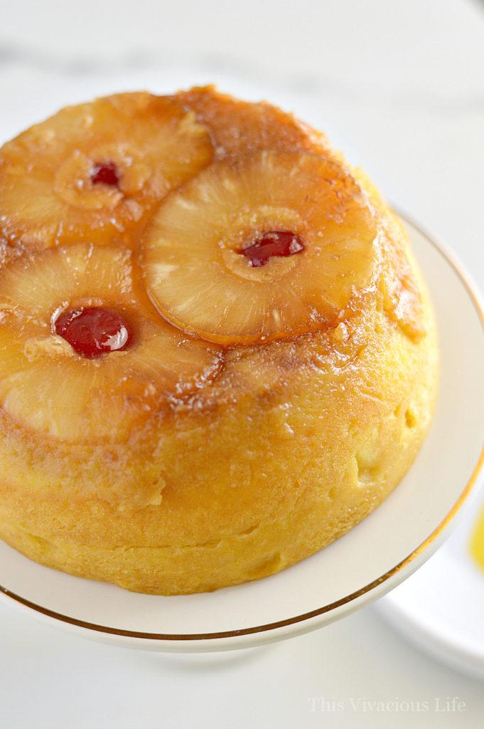 Pineapple upside down cake on a white pedestal