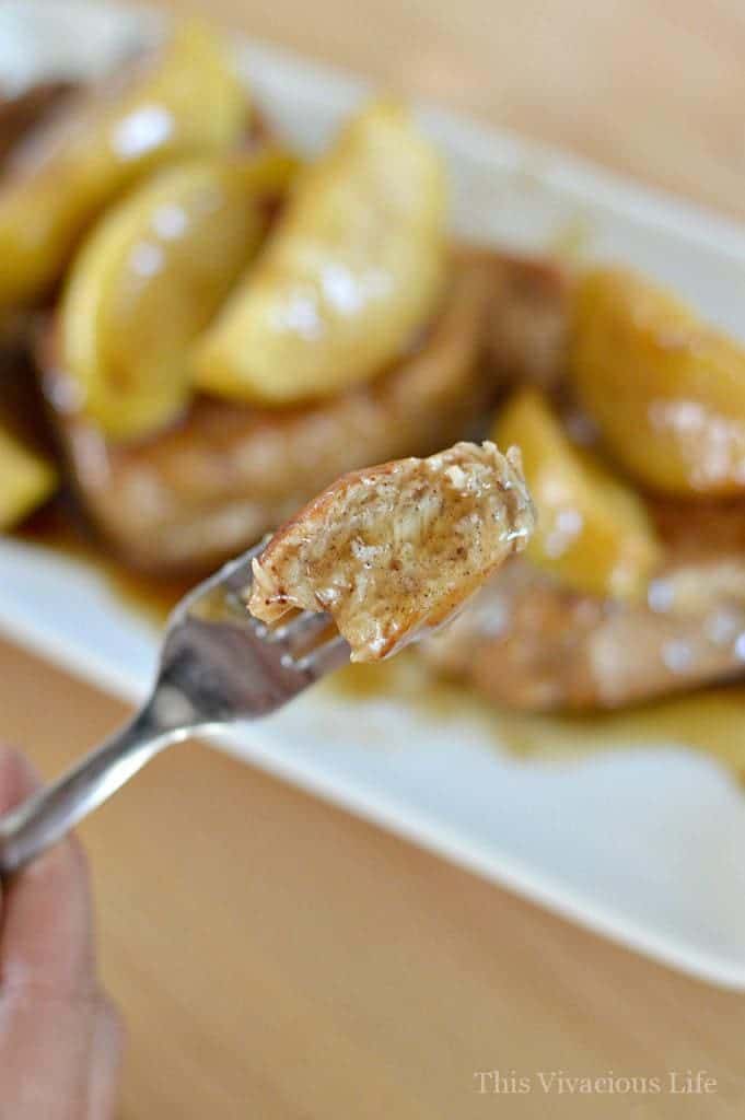 Piece of pork on a fork with cinnamon apples and sauce