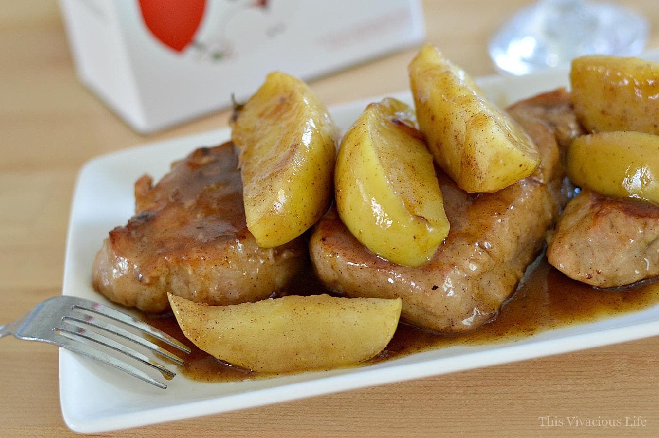 Pork chops and cinnamon apples on a white plate with a fork