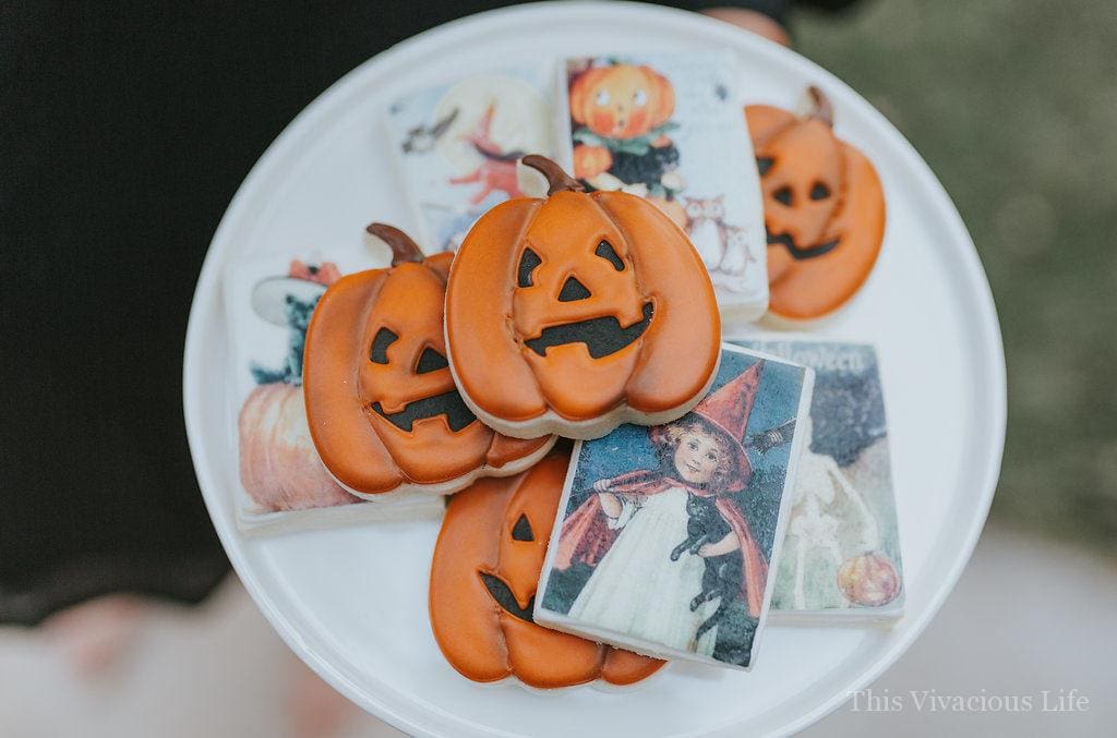 Halloween jack o' lantern and witch cookies on a white plate