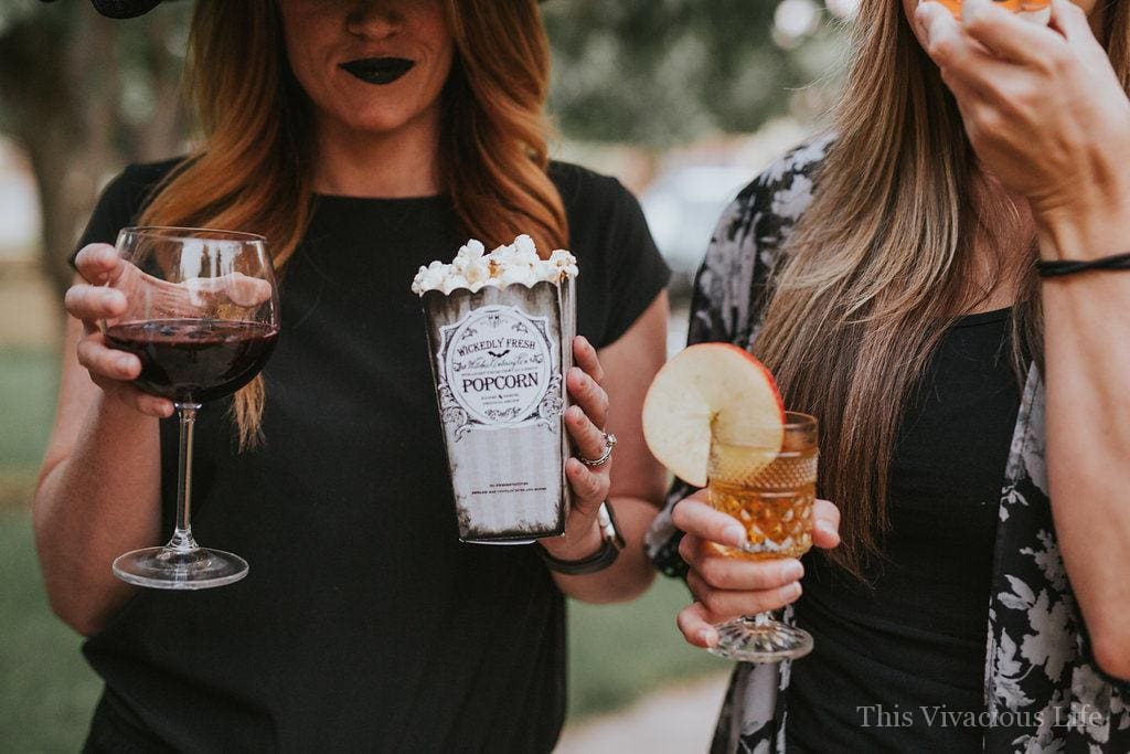 Ladies holding Halloween Mocktails and popcorn