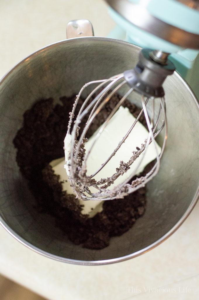 Chocolate cookie crumbs with cream cheese in a Kitchenaid