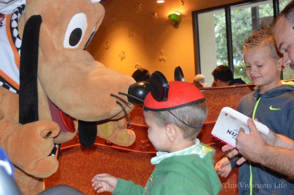 Two kids meeting Goofy at Disneyland