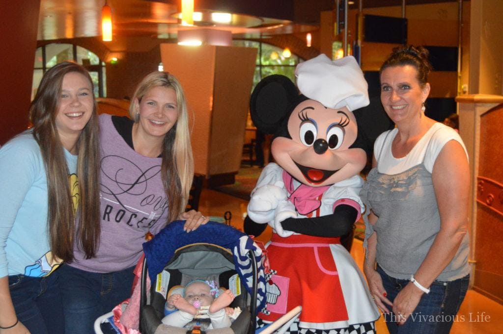 Three women and a baby meeting Minnie Mouse