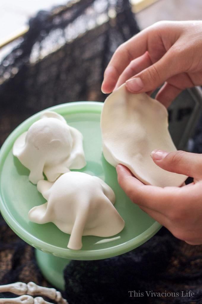 White fondant being placed on cookies