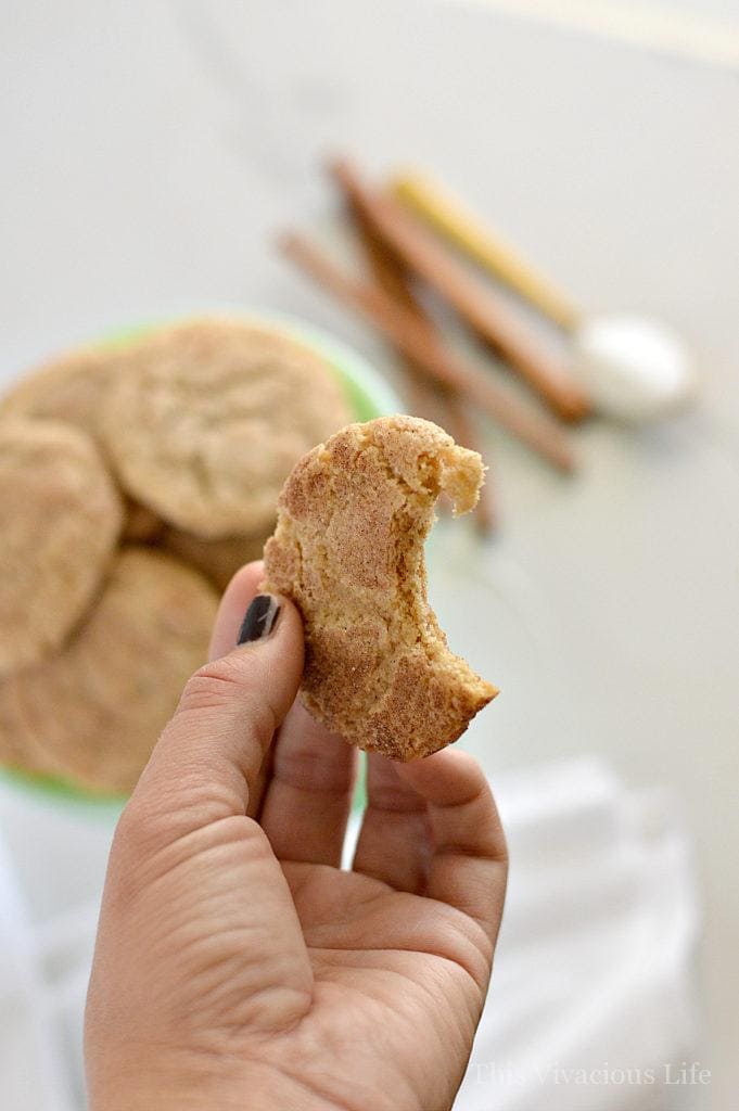 Hand holding a gluten-free snickerdoodles with a bite taken out