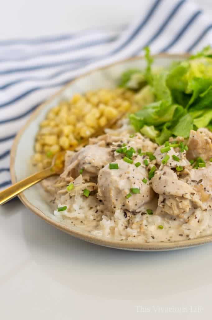 Creamy Italian chicken with corn and salad on a clay plate