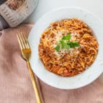 Spaghetti in a white bowl next to an Instant Pot