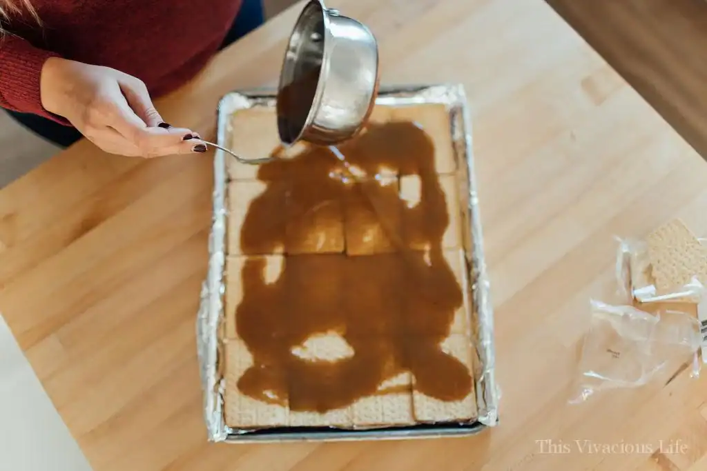 christmas crack step by step instructions with hand pouring butter mixture on crackers