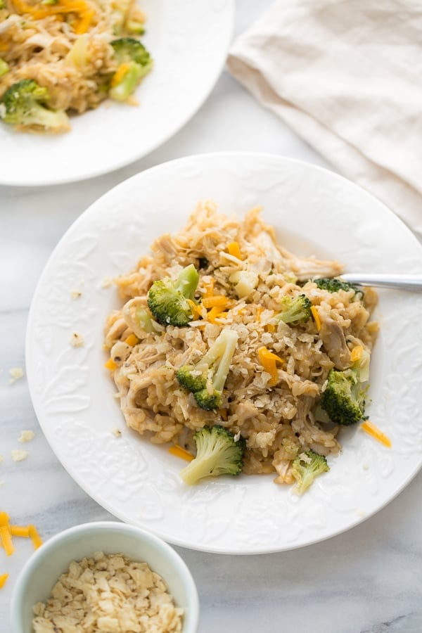 White bowl filled with rice, broccoli, cheese and chicken