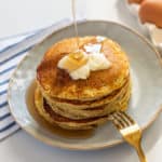 Shortstack of pancakes with syrup being drizzled on top