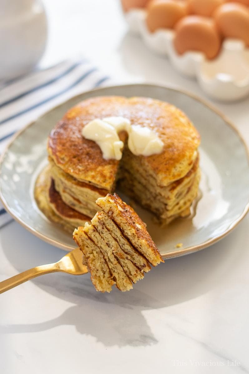 Short stack of pancakes with butter and a bite on a fork