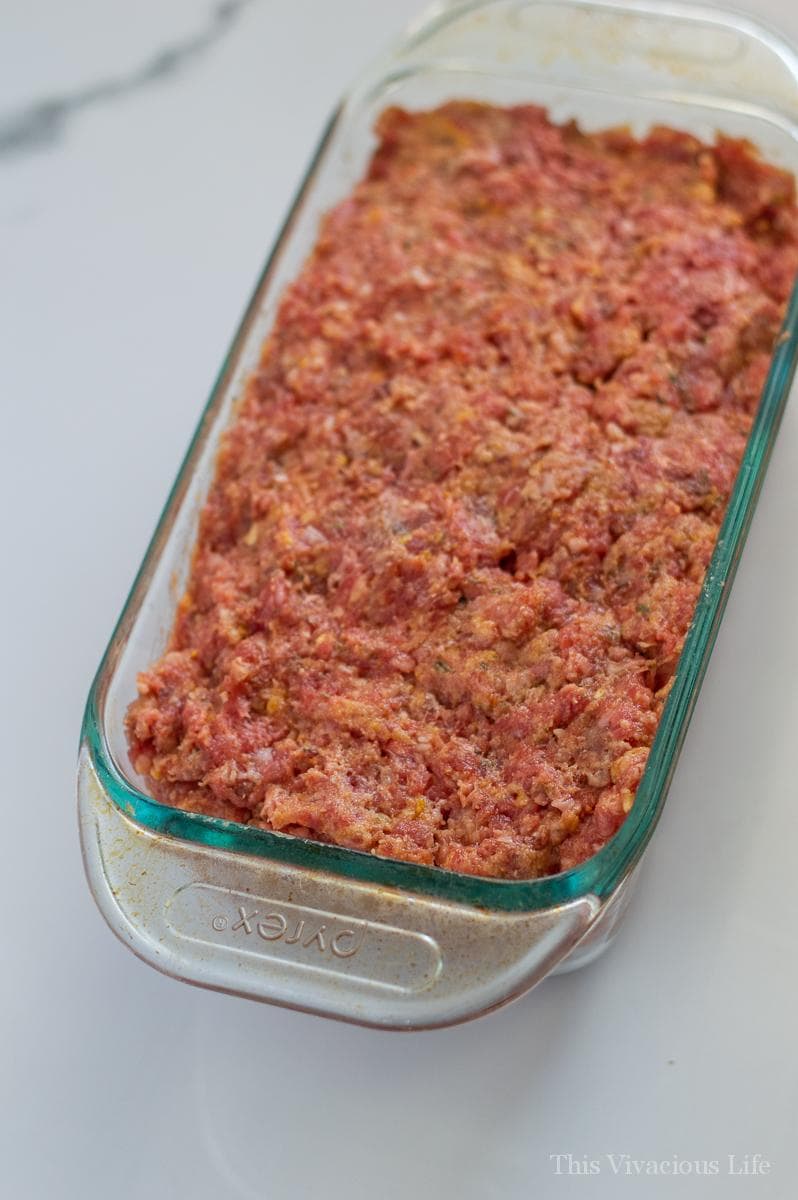 Raw meatloaf in a clear glass pan