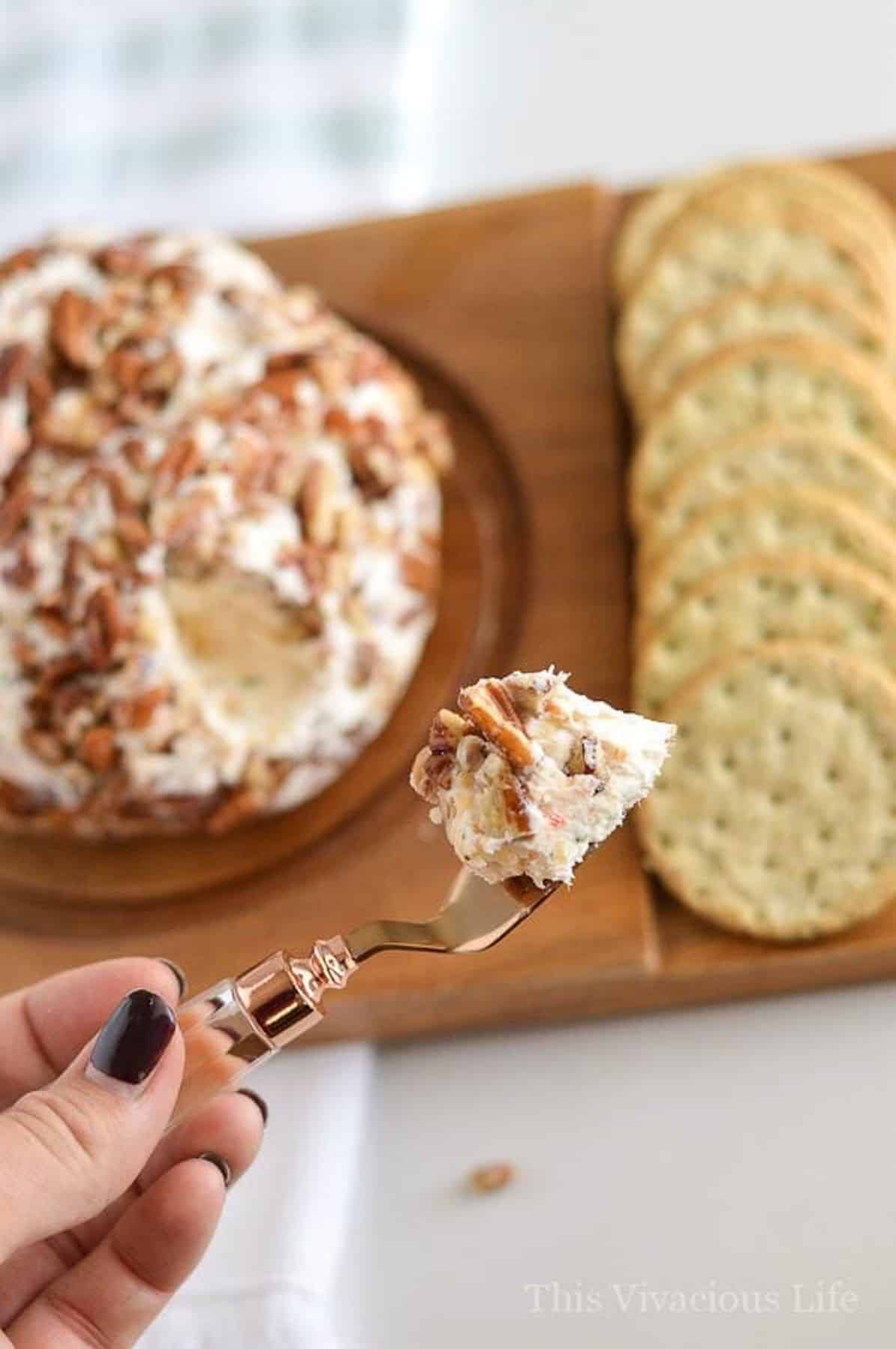 BEST cheeseball on a serving spoon in hand