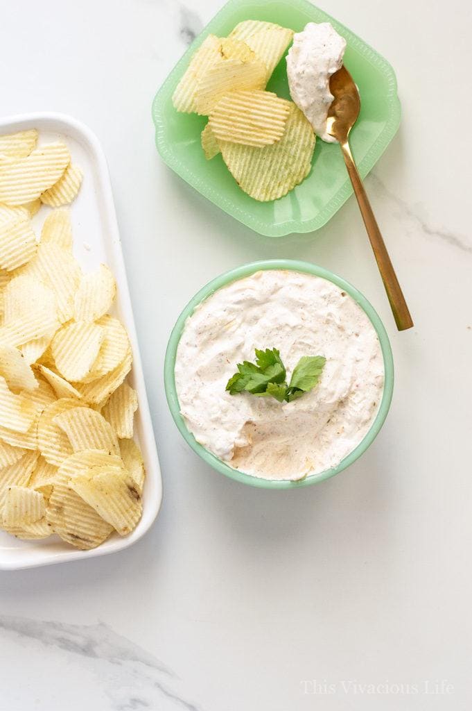 An overhead view of Sour Cream Dip with Cream Cheese & Cheddar next to a Ridged Chips