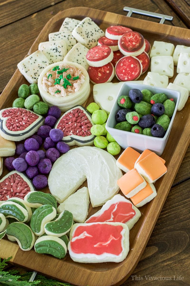 Charcuterie Cheese Board Cookies! These charcuterie cheese board cookies are so realistic and fun! They make a wonderful dessert after a delicious cheese and charcuterie board spread. Really though, these charcuterie sugar cookies made into cracker sugar cookies, cheese sugar cookies, olive sugar cookies, pickle sugar cookies and salami sugar cookies are really going to WOW anyone you serve them too!