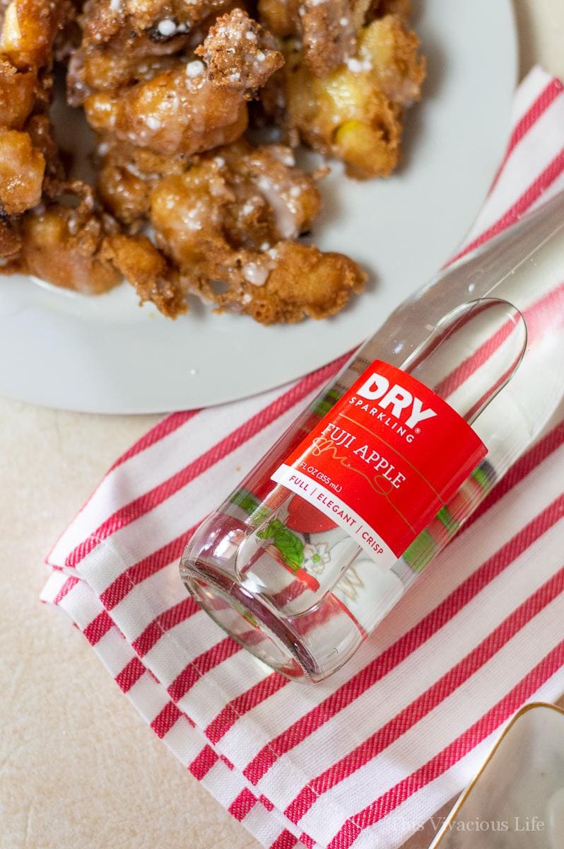 Bottle of apple soda and plate of apple fritters
