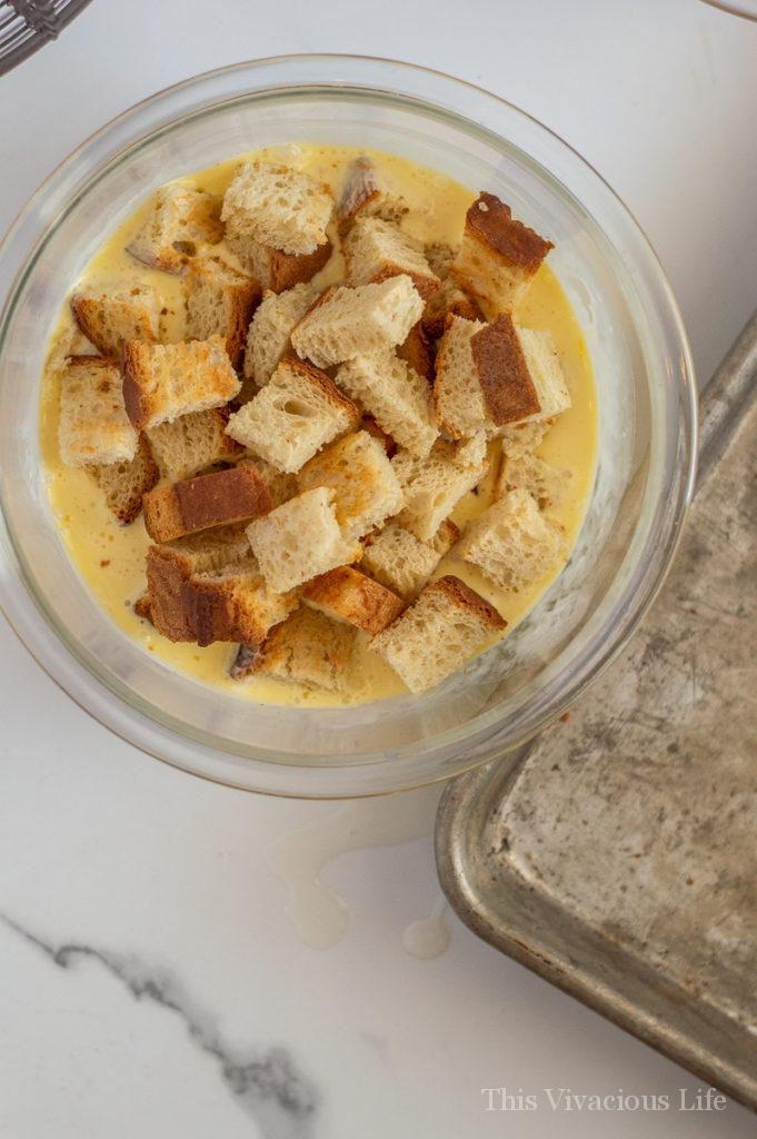 Bread cubes in a bowl of egg mixture