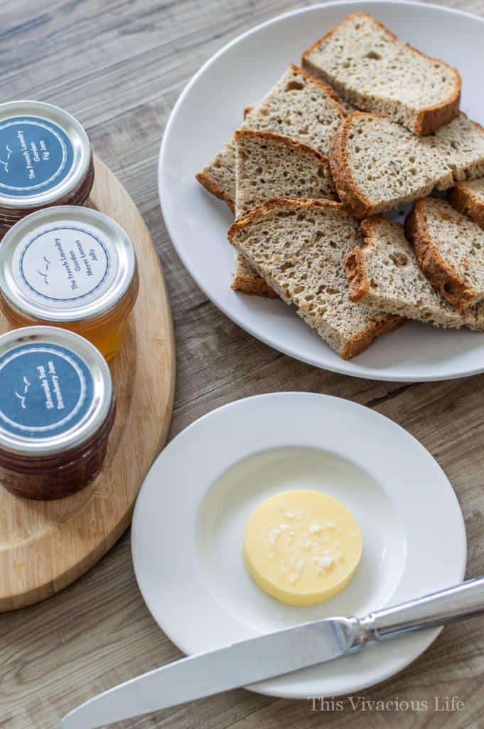 Three jam jars, sliced gluten-free bread and butter