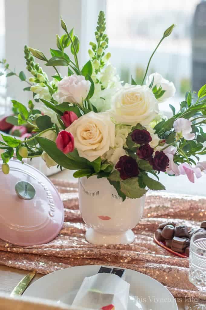 Bouquet of flowers in a face vase on a pink tablecloth