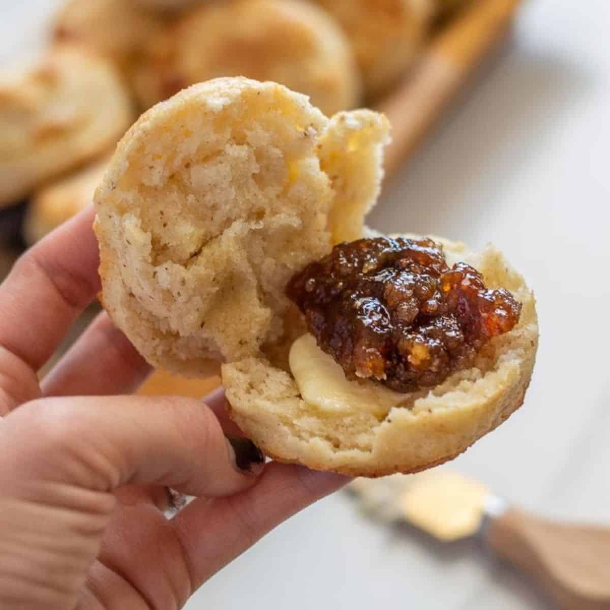 gluten free biscuits in a hand with butter and jam