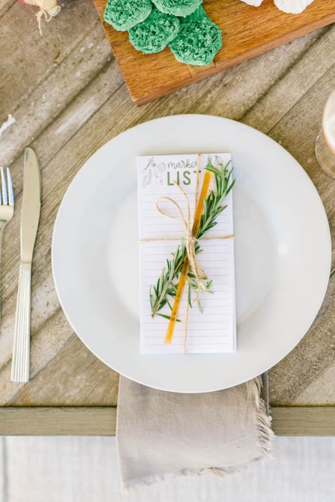 White plate with grocery list and rosemary tied