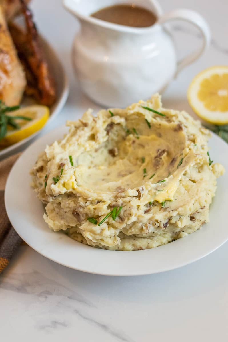 Mashed potatoes with butter and chives in a white bowl