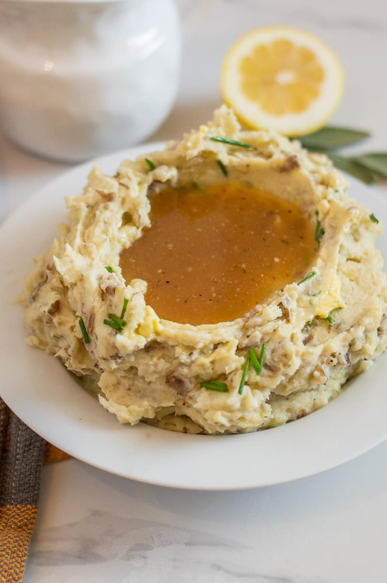 Mashed potatoes with gravy in a white bowl