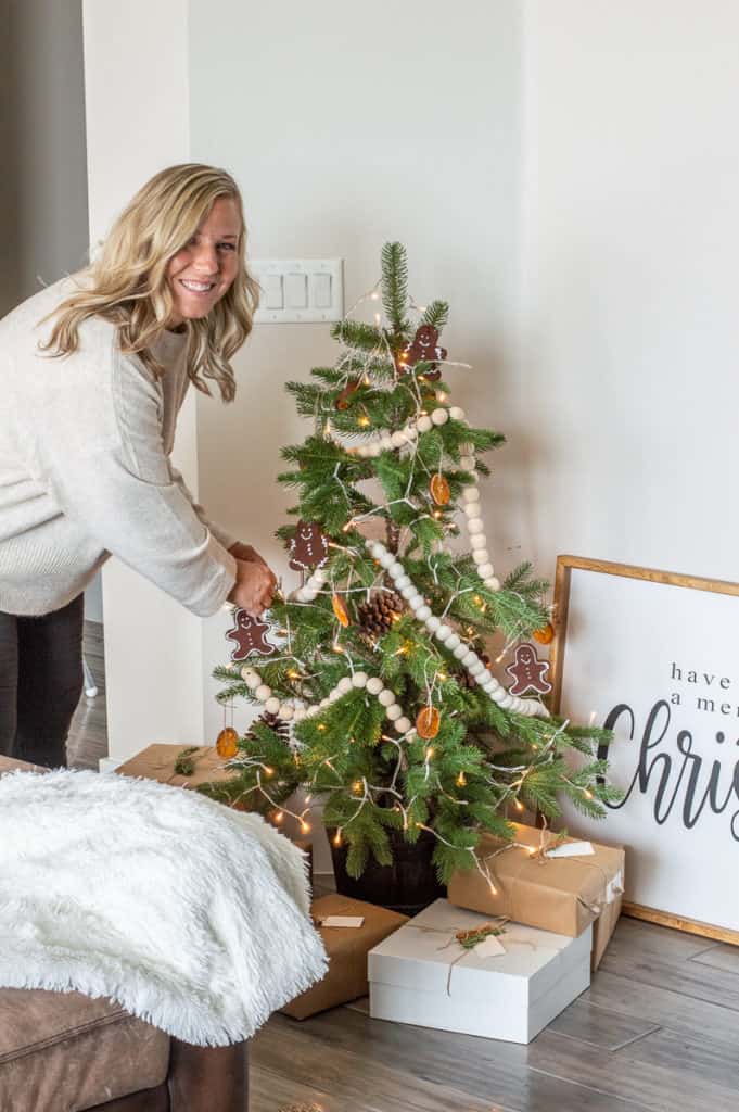 Girl decorating a modern Hygge Christmas tree