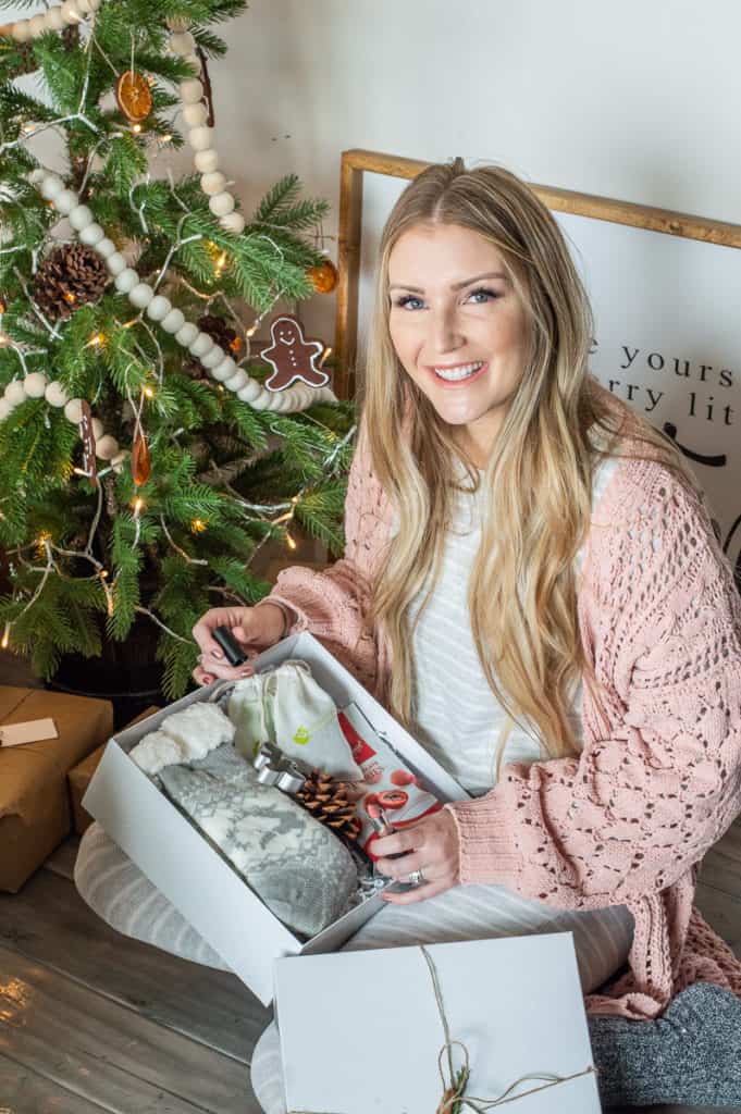 Girl next to a christmas tree with Hygge christmas gift basket
