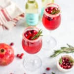 Prosecco drink with cranberries and rosemary in a glass flute