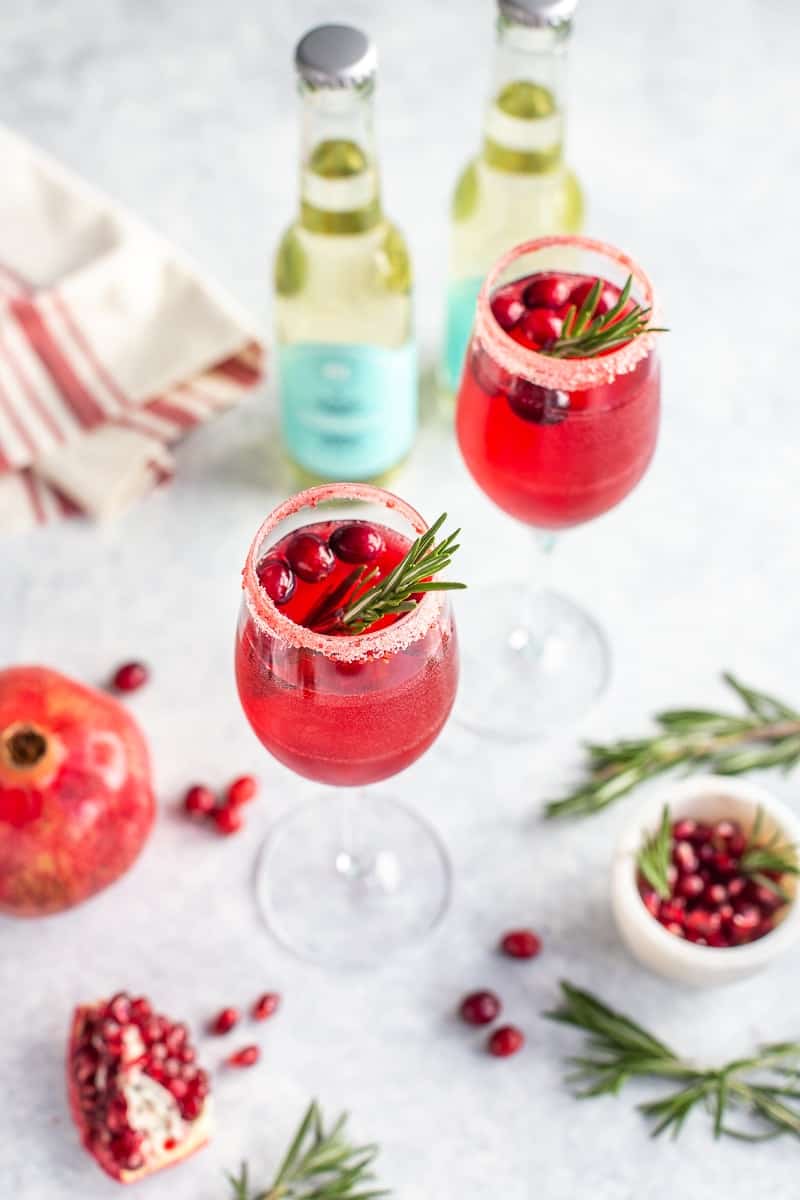 Non-alcoholic prosecco drink in glasses with cranberries, pomegranate and rosemary