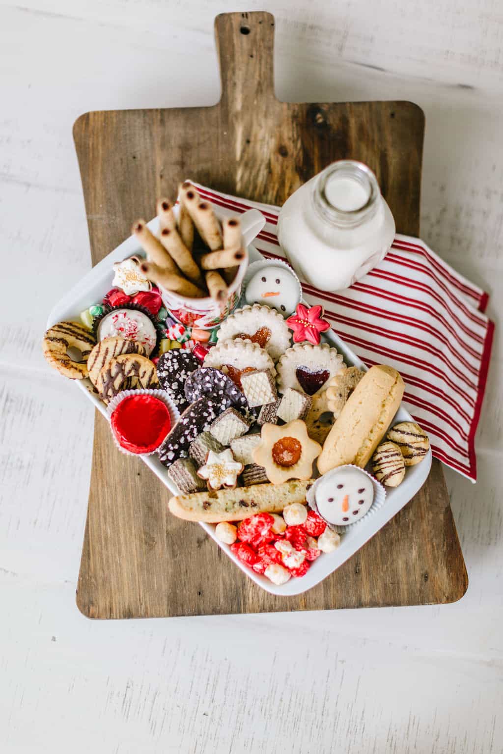Christmas cookies on a platter with towel and milk