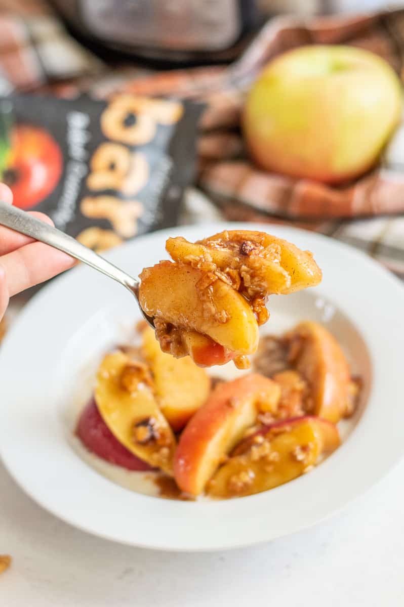Instant Pot apple crisp in a white bowl and on a spoon