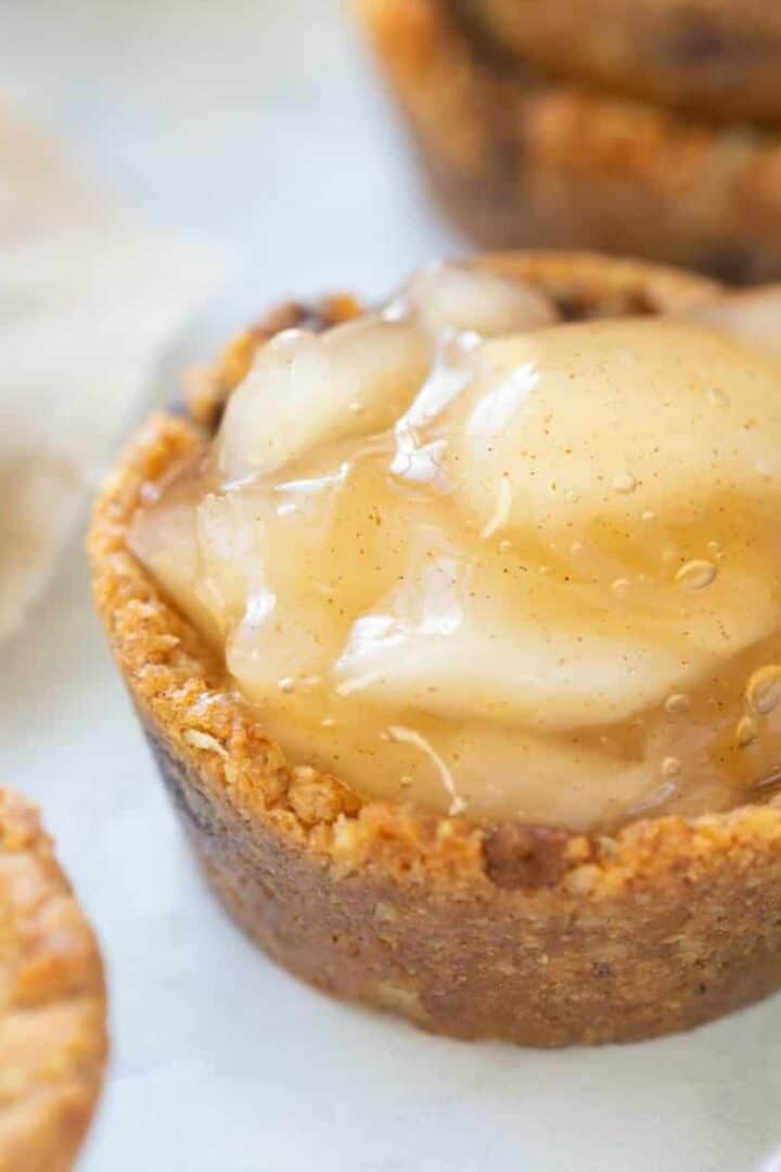 Easy Gluten Free Apple Pie Cookie Cups prepared with other cookie shells stacked in the back