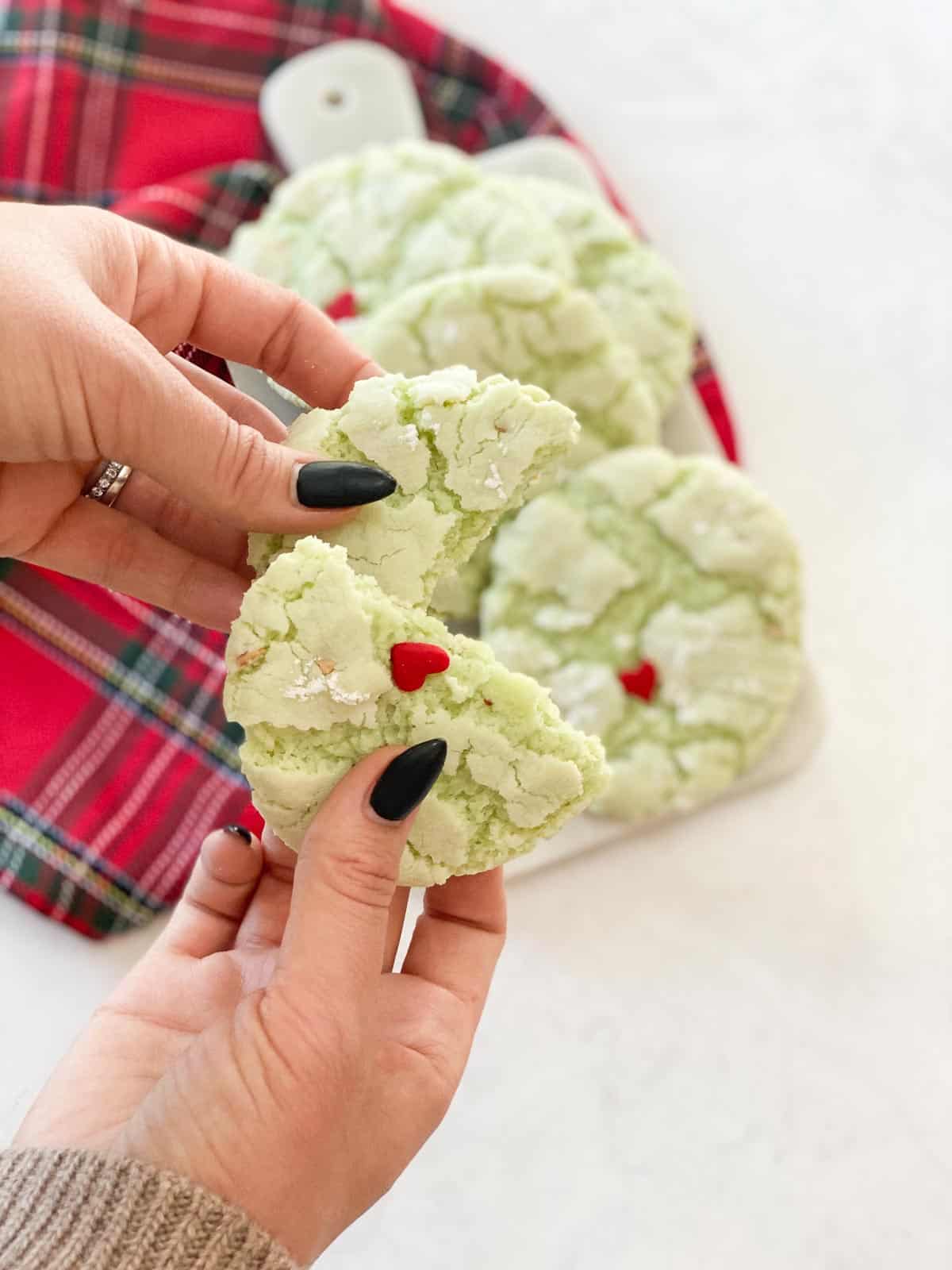Grinch cookies in a hand